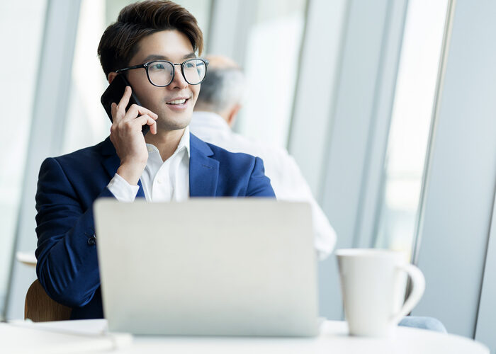 creative agency smart glasses asian male formal cloth conversation with smartphone freelance working with laptop at coworking area office space with freshness with blur office background